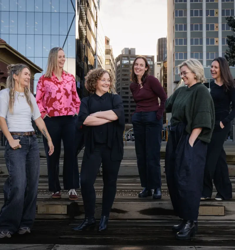 Virtual Marketers team standing together outdoors on a city waterfront - White-label marketing and agency expander capacity services