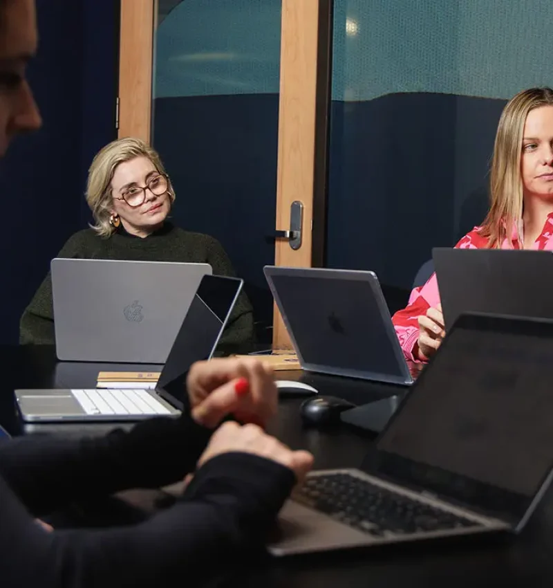 Marketing specialists reviewing work together on laptops - Comprehensive digital marketing audit services