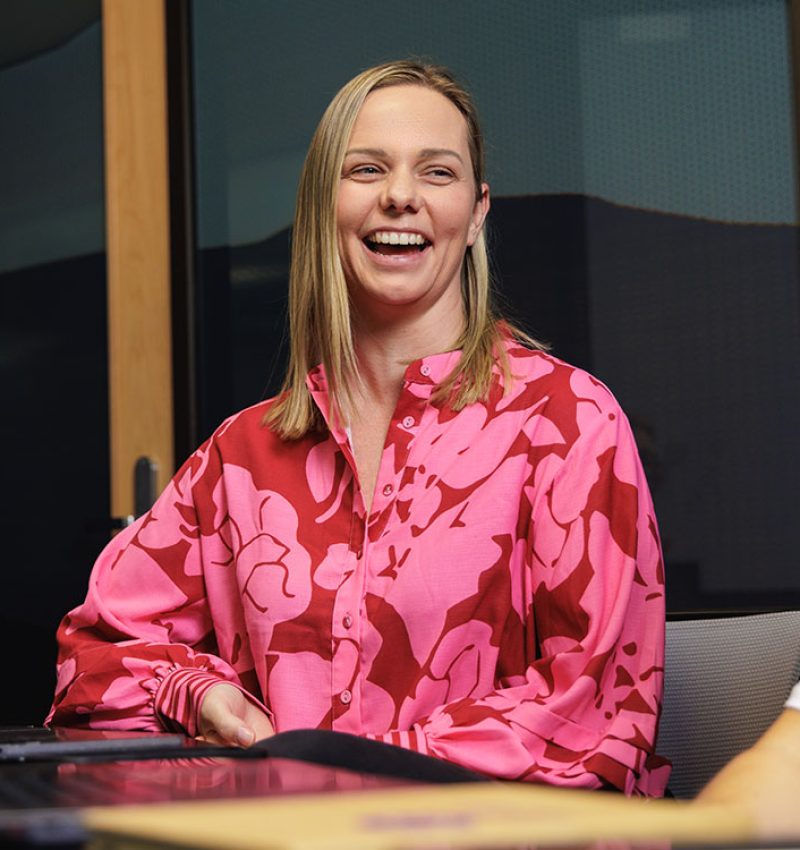 Smiling marketer in a pink top during a team discussion - AI and Answer Engine Optimisation (AEO) strategy for NZ brands